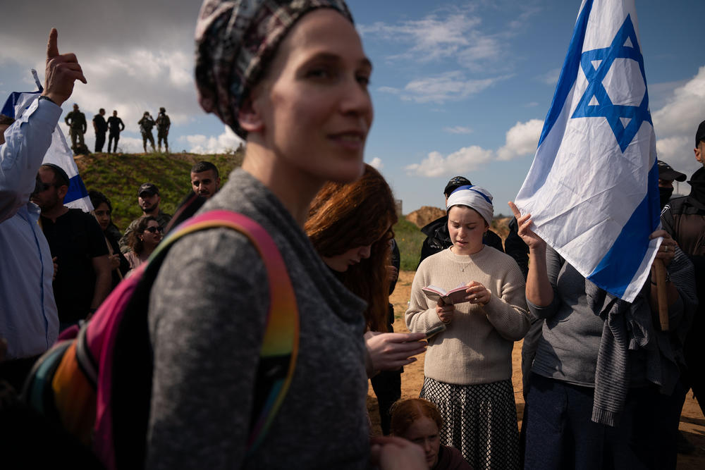 Israeli border police watch over protesters attempting to block the road as aid trucks cross into the Gaza Strip at the Kerem Shalom border crossing, southern Israel, Jan. 29, 2024.