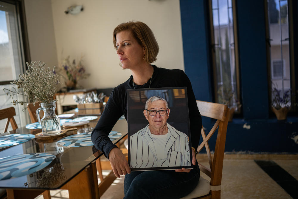 Carmit Palty Katzir holds a photo of her father, Rami, as she sits in her home in Haifa, Israel, on Feb. 18. Her father was killed at Kibbutz Nir Oz during the Oct. 7 Hamas-led attack on Israel. Her mother Hana and brother Elad were taken hostage. Israel's military said April 6 that it had recovered Elad's body after he was killed in captivity. Hana was released during the cease-fire in November.