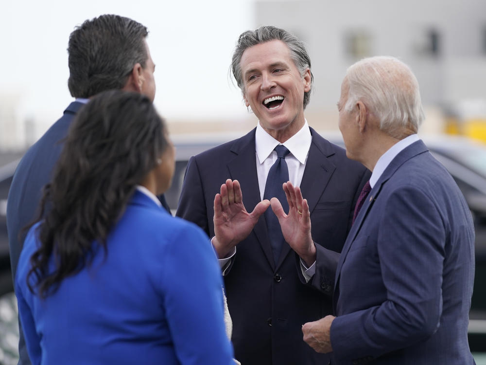 California Gov. Gavin Newsom talks with President Biden and other Democratic officials at San Francisco International Airport on Nov. 14, 2023.