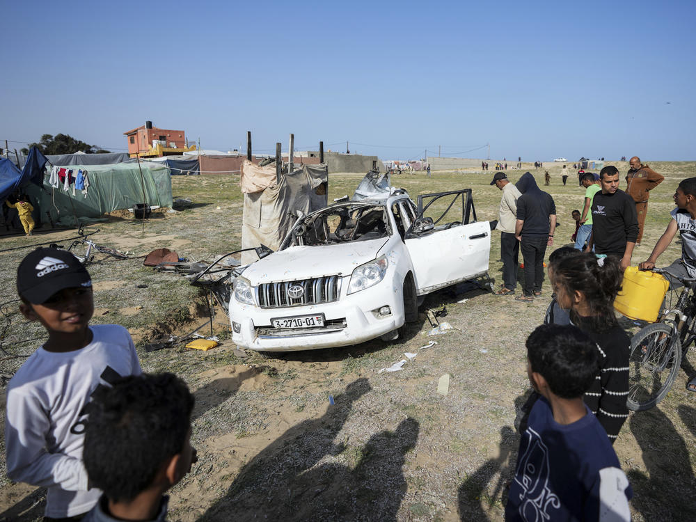 People inspect the site where World Central Kitchen workers were killed in Deir al-Balah, Gaza Strip, Tuesday. World Central Kitchen, an aid group, says an Israeli strike that hit its workers in Gaza killed seven people.
