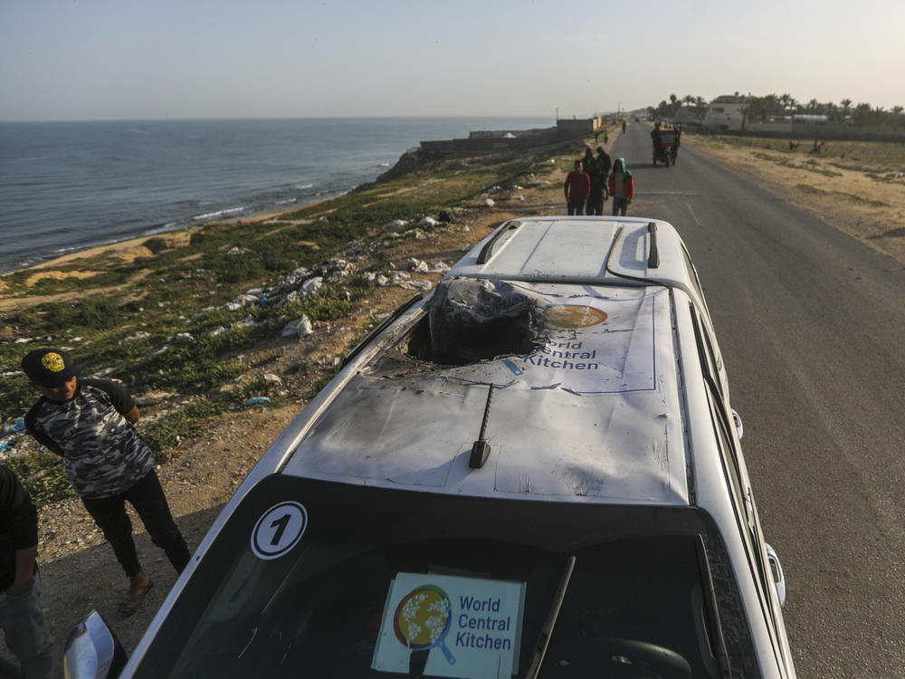 Palestinians inspect a vehicle with the logo of the World Central Kitchen wrecked by an Israeli airstrike in Deir al Balah, Gaza Strip.