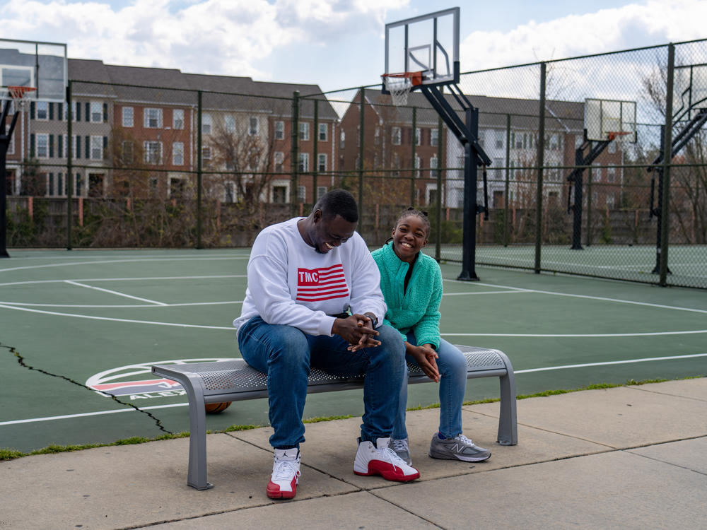 Joseph Yusuf sits with his daughter, Jakayla Morton, 11, at a basketball court in Alexandria, Va., on March 29.