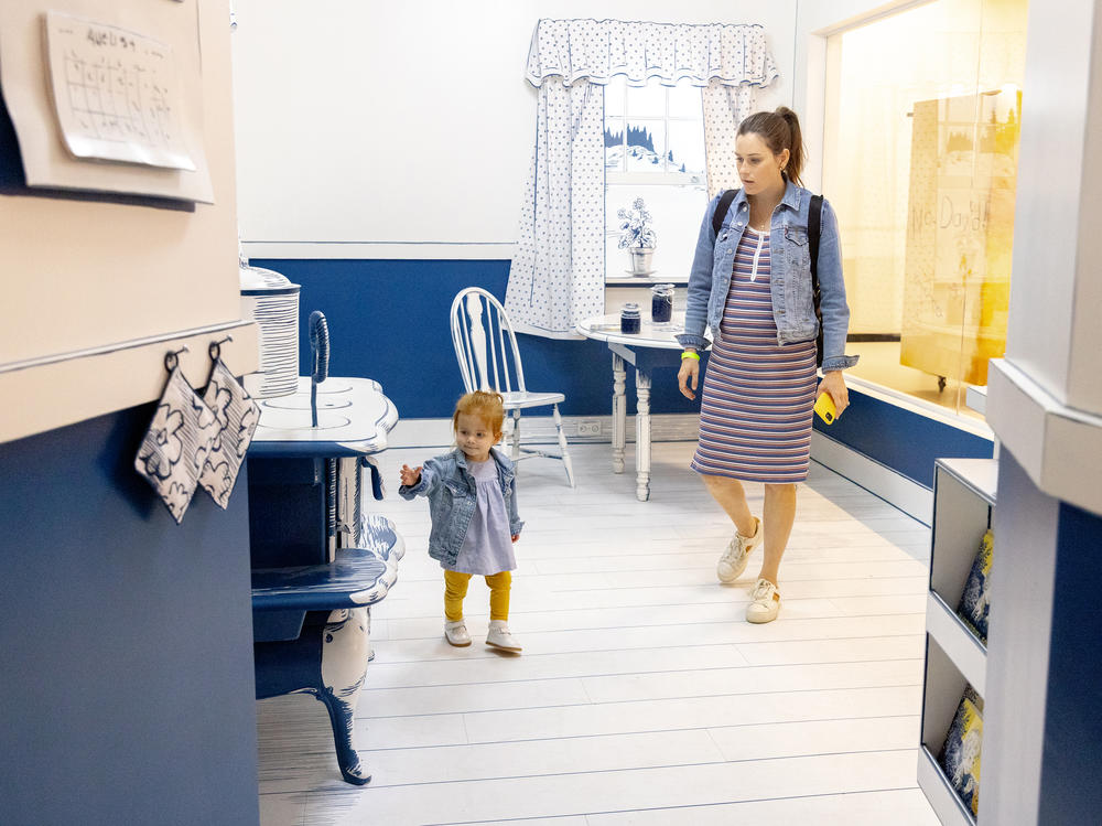 Madelyn Williams, 20 months, leads her mother, Nancy, through the kitchen from <em>Blueberries for Sal</em>, by Robert McCloskey.