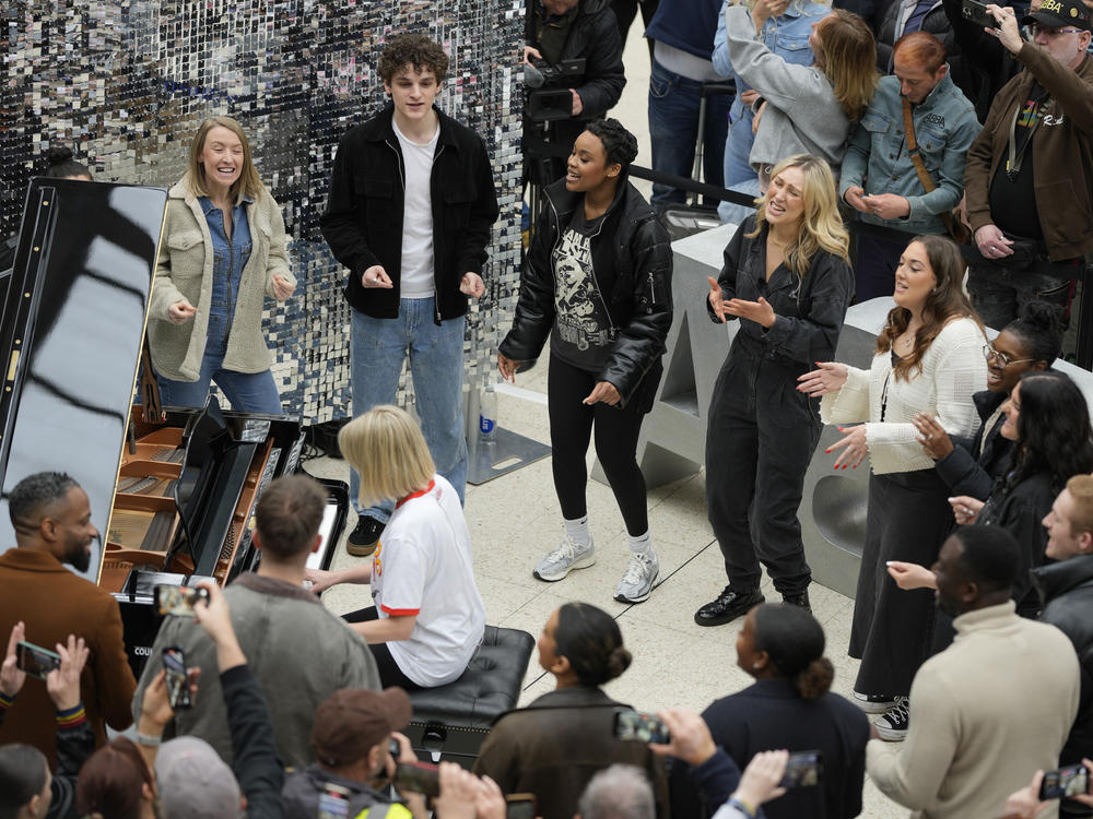 Members of the Mark de Lisser Singers perform the iconic ABBA song 'Waterloo' at Waterloo Station in London on Saturday, April 6, 2024.