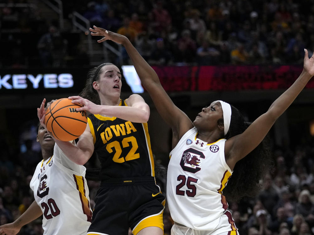 Iowa guard Caitlin Clark (22) passes over South Carolina guard Raven Johnson (25) during the first half of the college basketball championship game in the women's NCAA Tournament on Sunday in Cleveland.