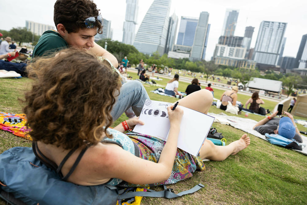A woman drawing the eclipse during the watch party at The Long Center for the Performing Arts in Austin, Texas.