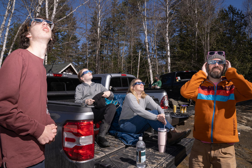 The Carter-Hill family and friends wait for the eclipse in Oquossoc Village in Rangeley, Maine.