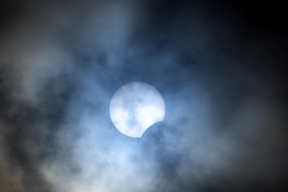 The moon begins to pass over the lower part of the sun during a total solar eclipse, seen from Pittock Mansion in Portland, Ore.