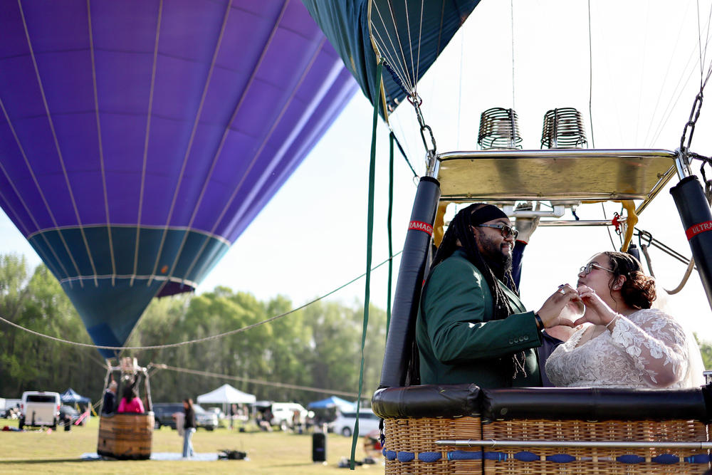 Bride and groom Kylee and Michael Rice prepare to take a hot air balloon ride before a planned mass wedding of over 200 couples at the Total Eclipse of the Heart festival in Russellville, Ark.