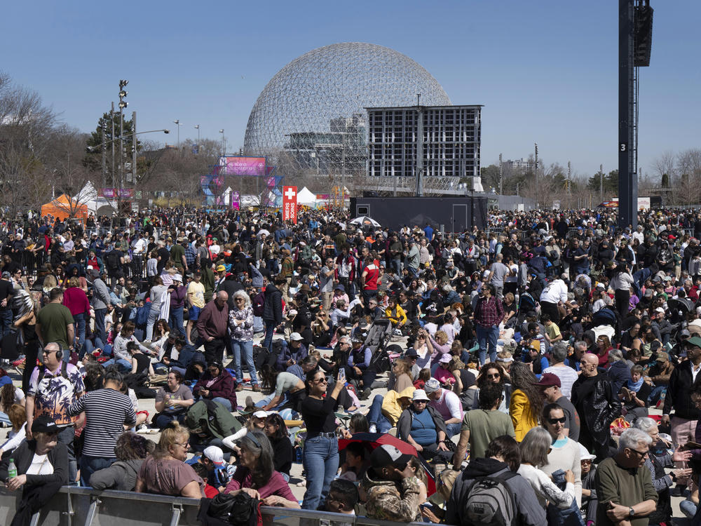 People gather to watch the total solar eclipse at Parc Jean Drapeau, in Montreal, Monday.