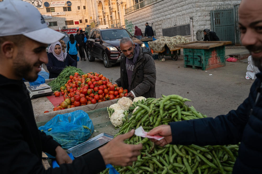 People shop for vegetables at a market in Ramallah in the occupied West Bank on March 24.