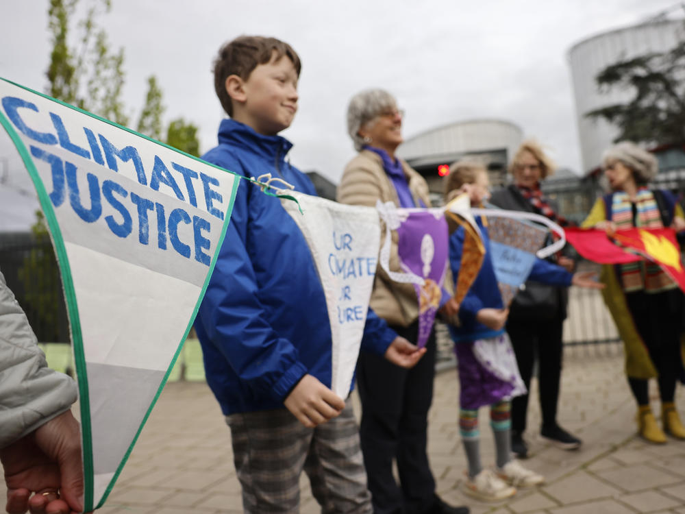People demonstrate outside the European Court of Human Rights Tuesday, April 9, 2024 in Strasbourg, eastern France.