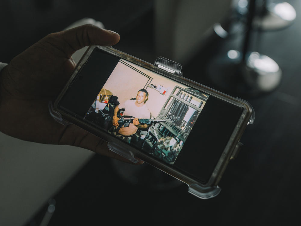 Edmund Garcia holds a photo of himself in 2000 as a specialist in charge of handling ammunition and supplies while he was in the Army.