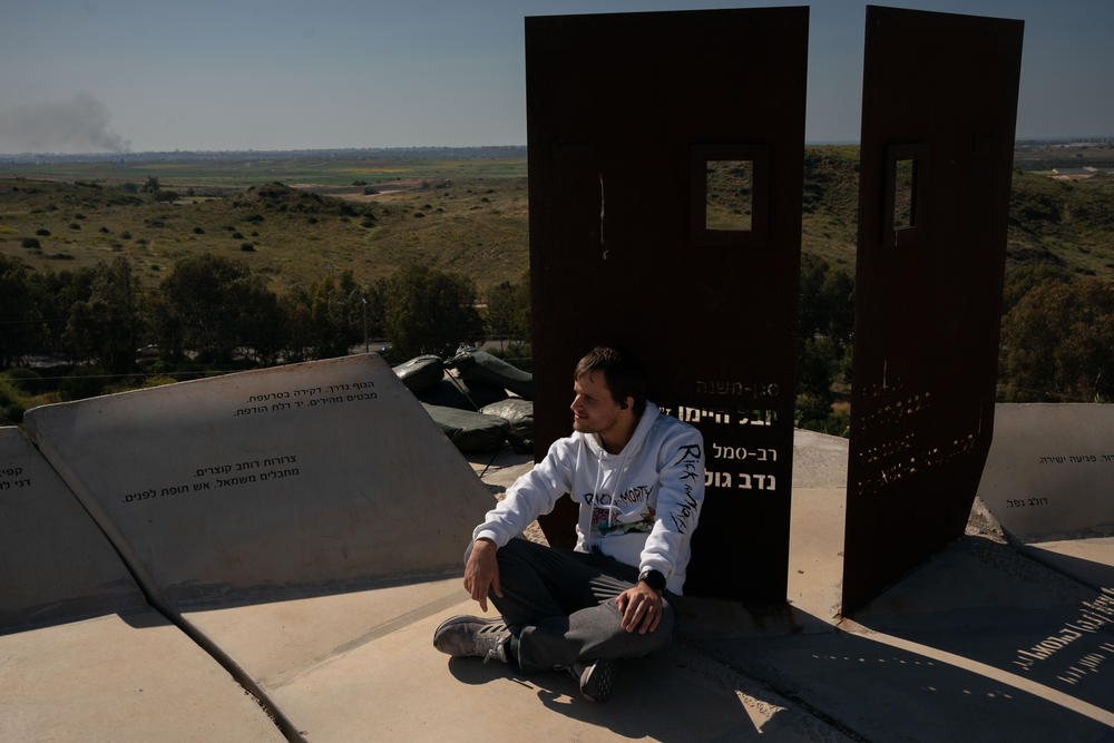 Oren Chen, 26, looks at Gaza from a hilltop viewpoint in Sderot on March 20, as smoke rises from Gaza.