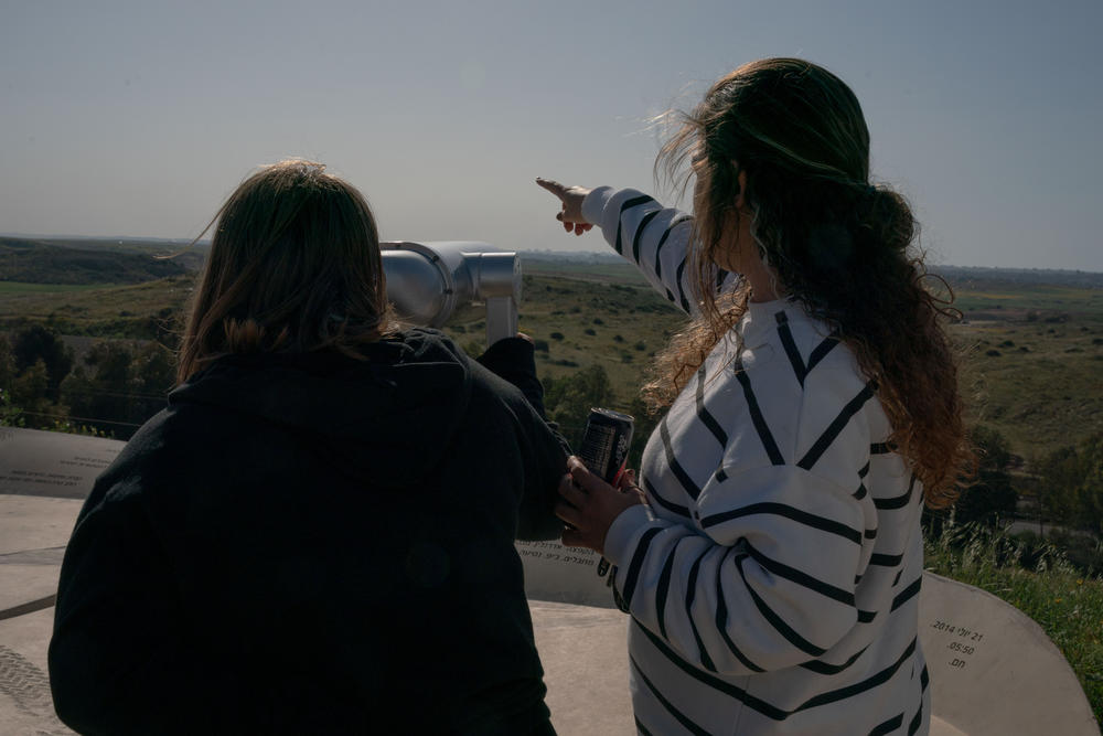 From a hilltop viewpoint in Sderot, girls on a school trip look toward smoke rising from Gaza on March 20.