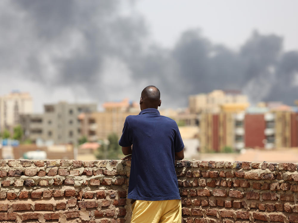 A man looks at the smoke rising next to the Army General Command in Khartoum, Sudan, on April 16, 2023.