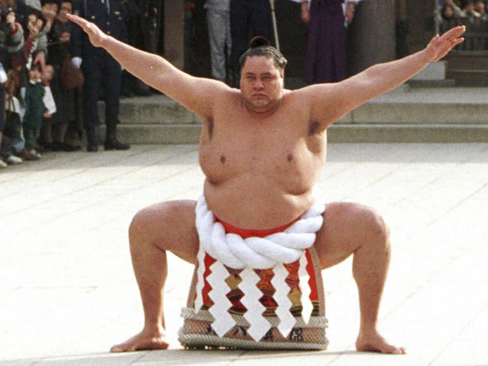 Accompanied by a sword-bearer, grand champion Akebono, right, performs the ring-entrance ritual during the annual New Year's dedication at Meiji Shrine in Tokyo, on Jan. 8, 1997.