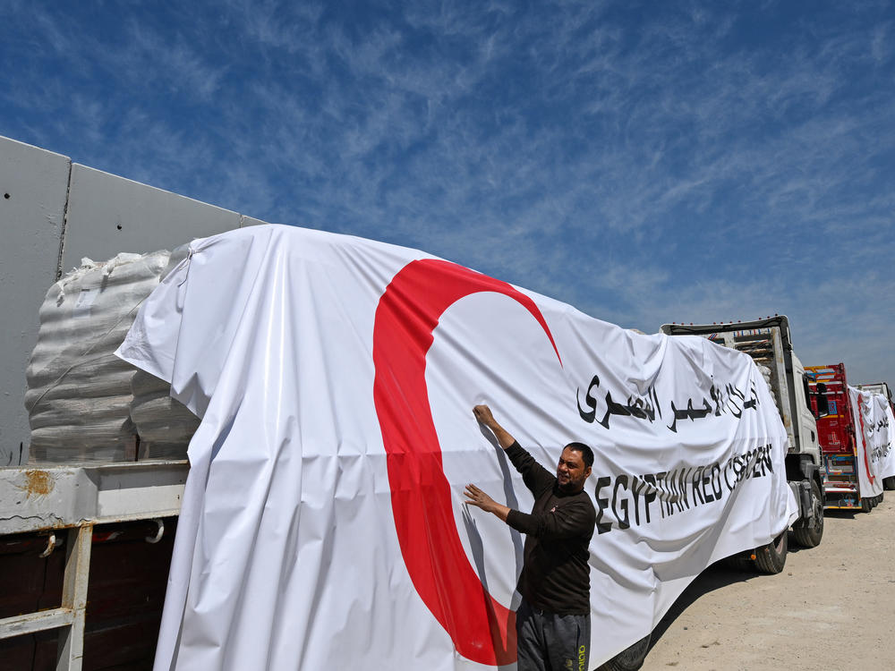 Egyptian Red Crescent trucks loaded with aid queue outside the Rafah border crossing with the Gaza Strip on March 23. After months of very limited aid deliveries to Gaza, the pace is picking up this week. More than 400 trucks are entering Gaza daily, according to Israel. This is more than double the previous rate.