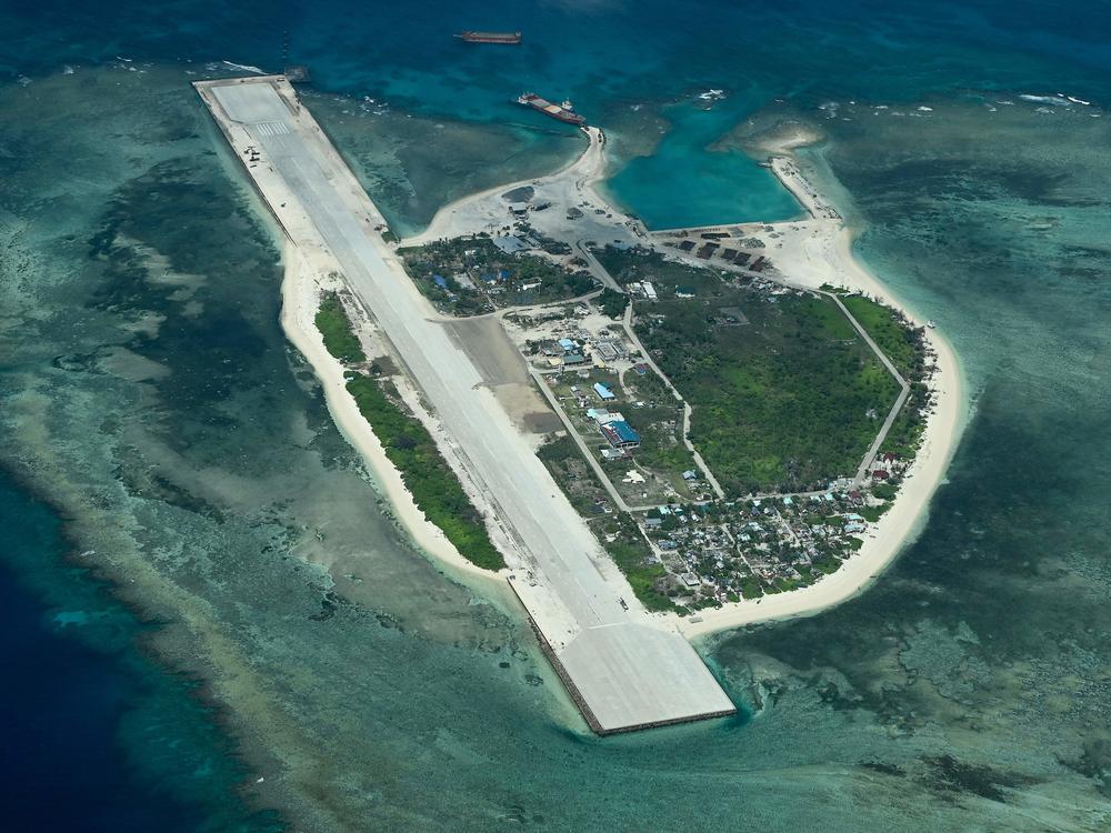 An aerial view taken on March 9, 2023 shows Thitu Island in the South China Sea. - As a Philippine Coast Guard plane carrying journalists flew over the Spratly Islands in the hotly disputed South China Sea, a Chinese voice issued a stern command over the radio: 