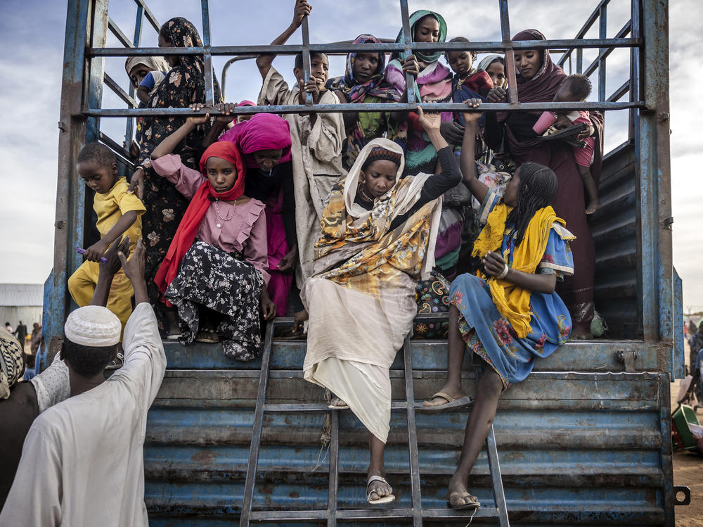 Sudanese refugees who have fled from the war in Sudan get off a truck loaded with families arriving at a transit center for refugees in Renk, South Sudan, on Feb. 13.