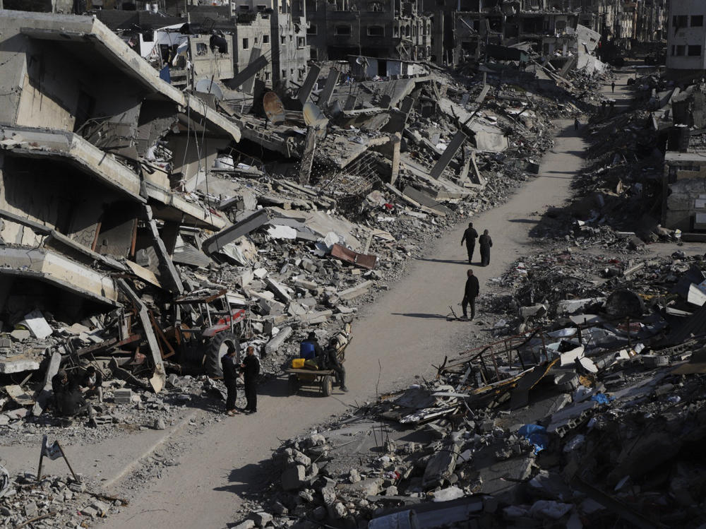 Palestinians walk through the destruction from the Israeli offensive in Jabaliya refugee camp in the Gaza Strip earlier this year.
