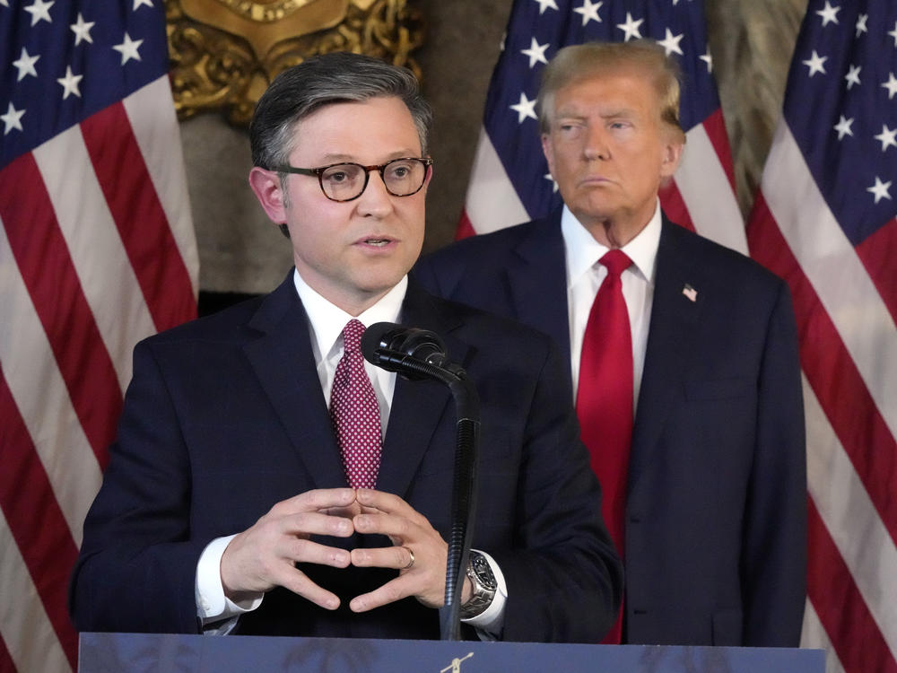 House Speaker Mike Johnson, R-La., speaks as former President Donald Trump listens during a news conference Friday at Trump's Mar-a-Lago resort in Palm Beach, Fla.