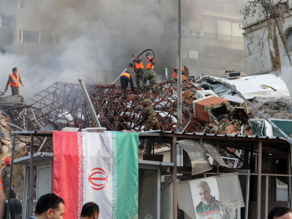 Emergency and security personnel extinguish a fire at the site of strikes that hit a building annexed to the Iranian embassy in Syria's capital Damascus on April 1. Iran blames Israel for the attack.