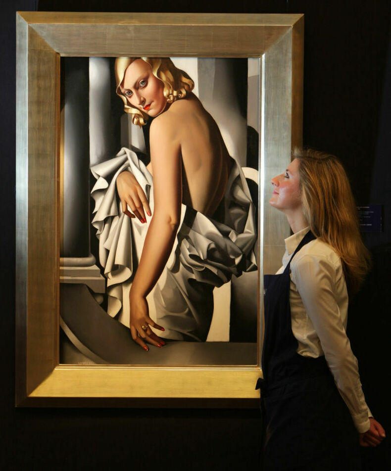 A gallery technician at Sotheby's auction house admires a painting by Tamara de Lempicka in 2009 entitled <em>Portrait de Marjorie Ferry</em> from 1932.