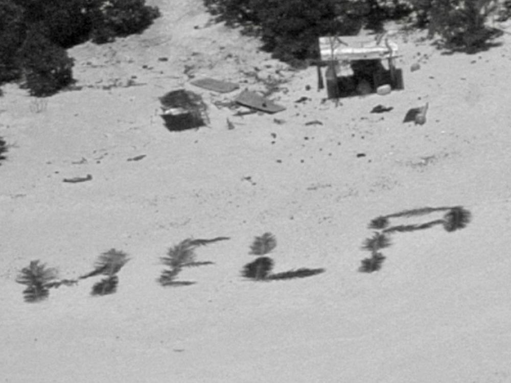 The 'HELP' sign made from palm fronds is shown on the Pikelot atoll.