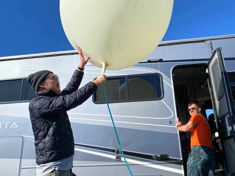 Song holds a balloon while Iseman watches from the RV. 