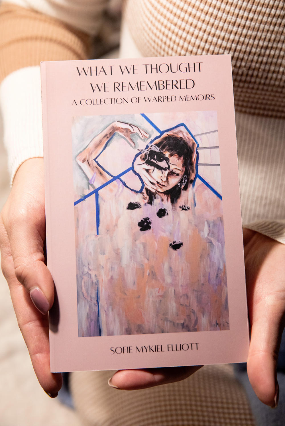 Sofie Elliott displays the book she wrote about her and her sister's shared project about memories.