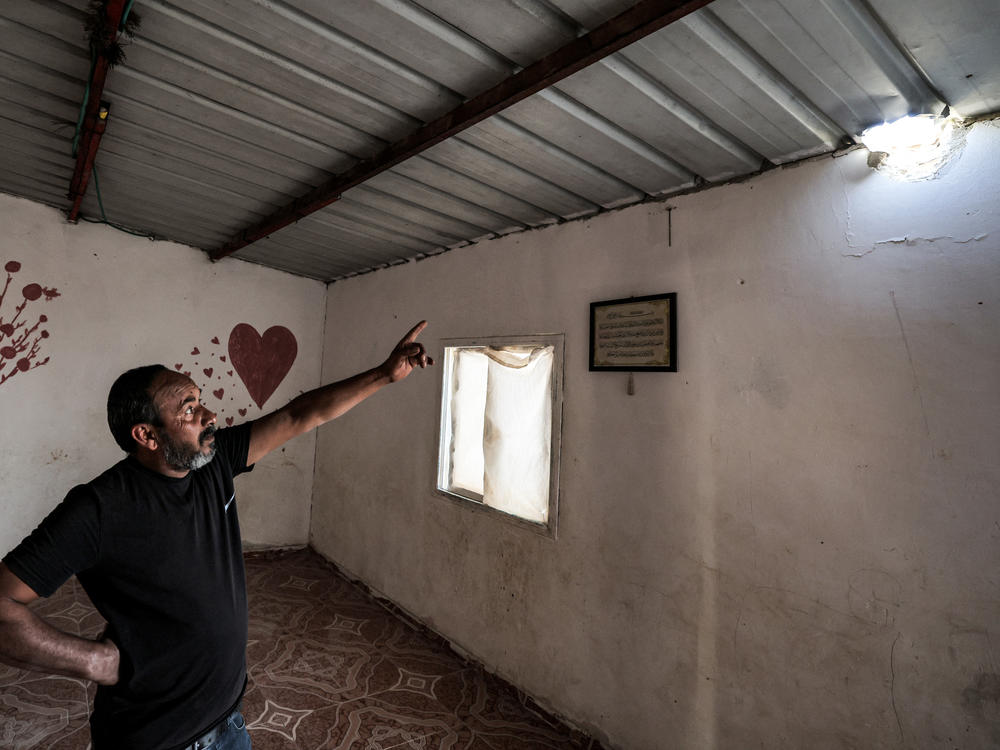 Mohamad Hassouna, 49, points to a hole in the roof of a building caused by a projectile that injured his 7-year-old daughter at their Bedouin village in the southern Negev desert on Sunday.
