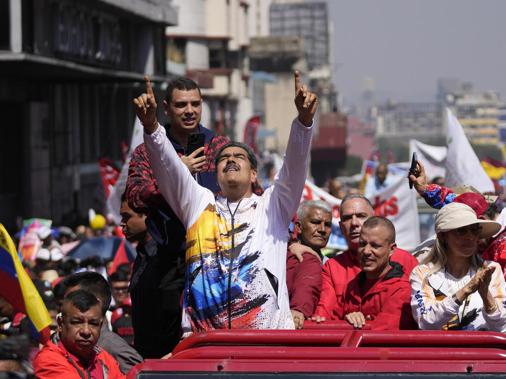 Venezuelan President Nicolás Maduro points upward as he is driven to the electoral council headquarters to register his candidacy for a third term, in Caracas, Venezuela, March 25.