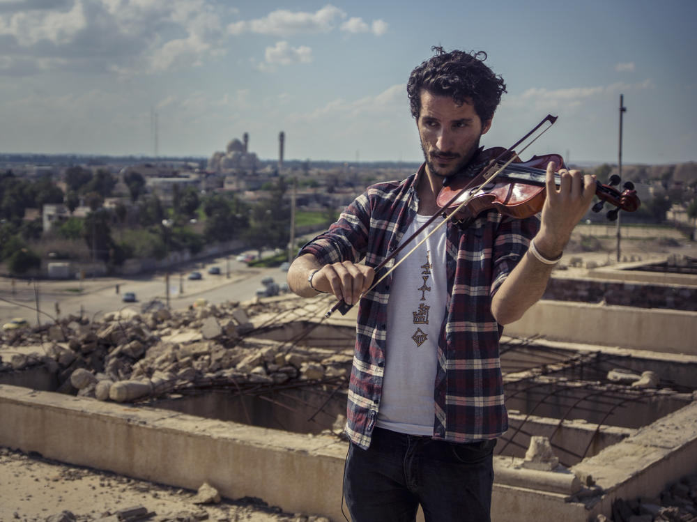 أمين مقداد يعزف على الكمان في الموصل، العراق.