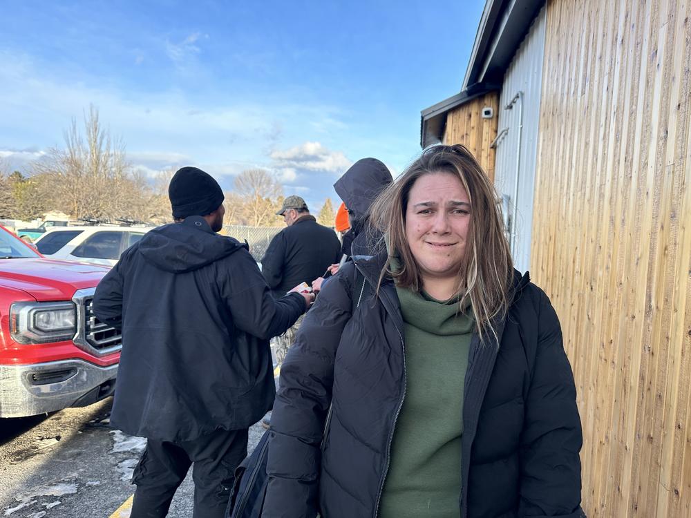 Tashya Evans waiting outside at the Flathead Warming Center, a low-barrier shelter in Kalispell, Mont. on March 5, 2024. Evans had just finished work in time to join the line for a bed that evening.