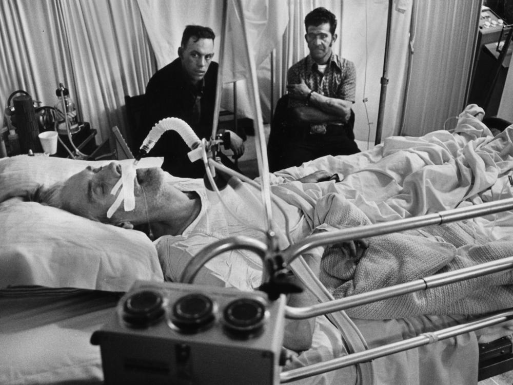 Jess Bishop takes his last breaths while his sons — also coal miners — keep vigil in Logan County, W.Va., in 1976. Since 2010, more than 4,000 coal miners have been diagnosed with advanced black lung disease.