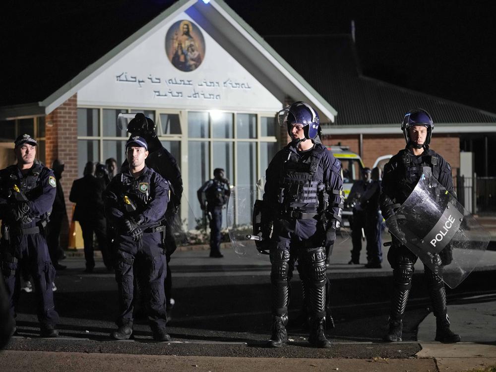 Security officers stand guard outside Orthodox Assyrian church in Sydney, Australia, Monday, April 15, 2024.