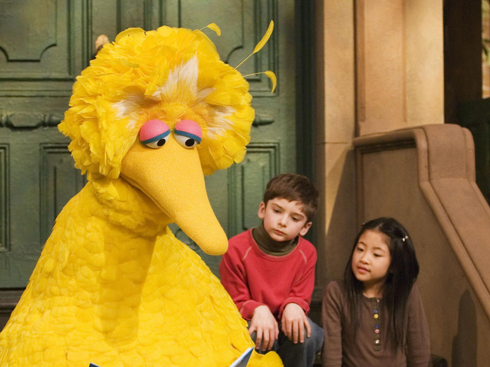 In this 2008 file photo, Big Bird reads to Connor Scott and Tiffany Jiao during a taping of <em>Sesame Street</em> in New York.