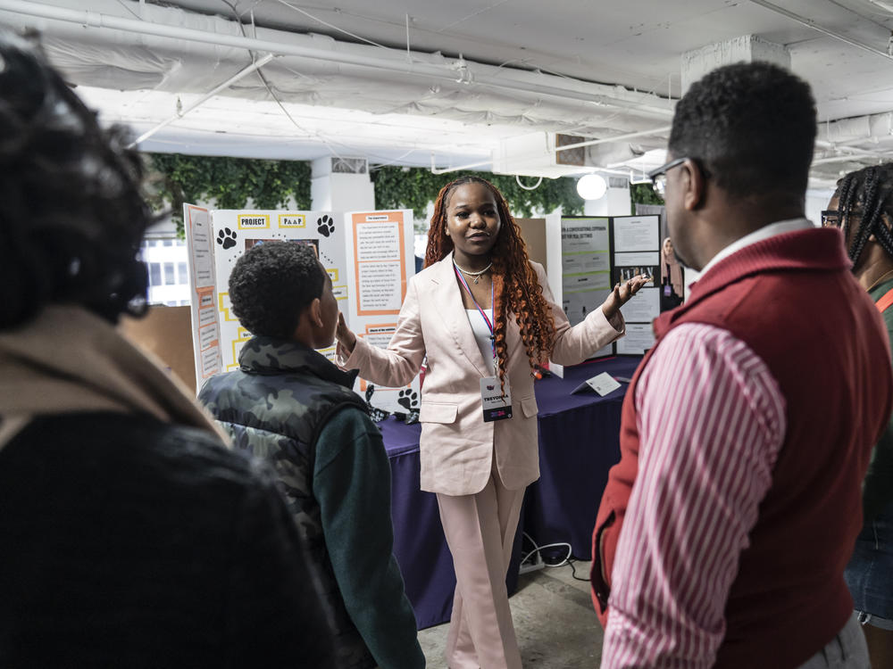 At the National STEM Festival, 12th-grader Treyonna Sullivan talks with visitors about her 