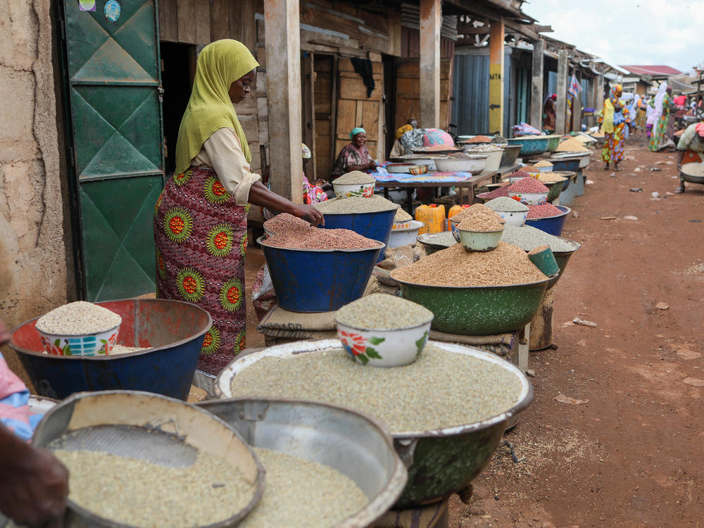 A vendor sorts grains at a market in Ghana. Fonio, a drought-resilient grain native to West Africa, could bolster the regional food supply if there are advances in its harvesting and processing.
