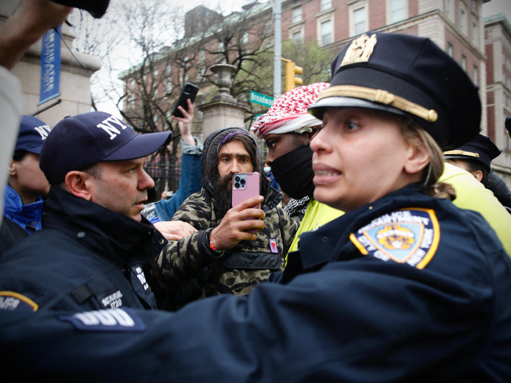 NYPD officers detain a person as pro-Palestinian protesters gather outside of Columbia University in New York City on Thursday. Officers cleared out a pro-Palestinian campus demonstration, a day after university officials testified about anti-Semitism before Congress.