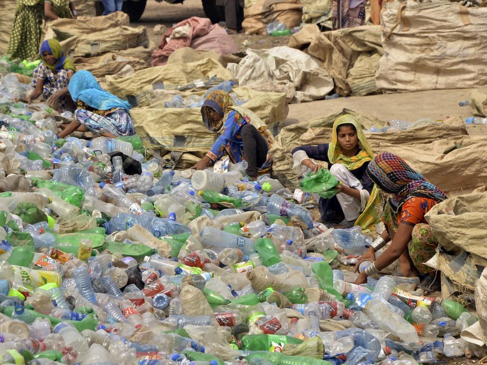 Pakistani laborers, mostly women, sort through empty bottles at a plastic recycling factory in Hyderabad, Pakistan.