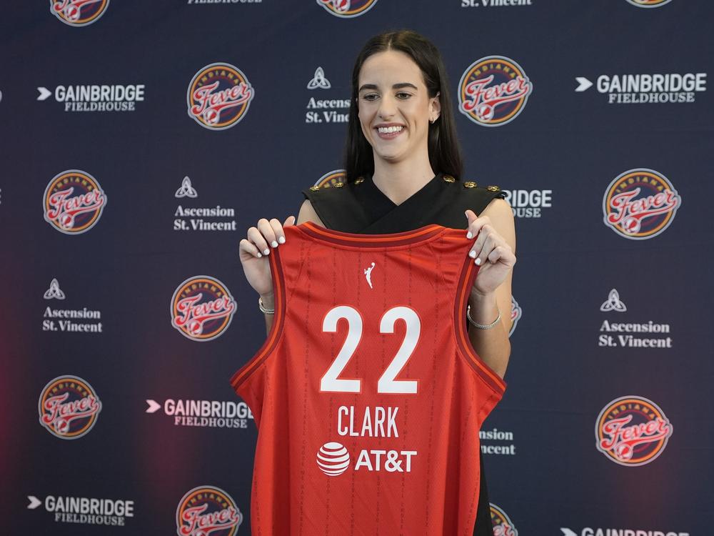 Clark holds up her Fever jersey after a Wednesday press conference in Indianapolis.