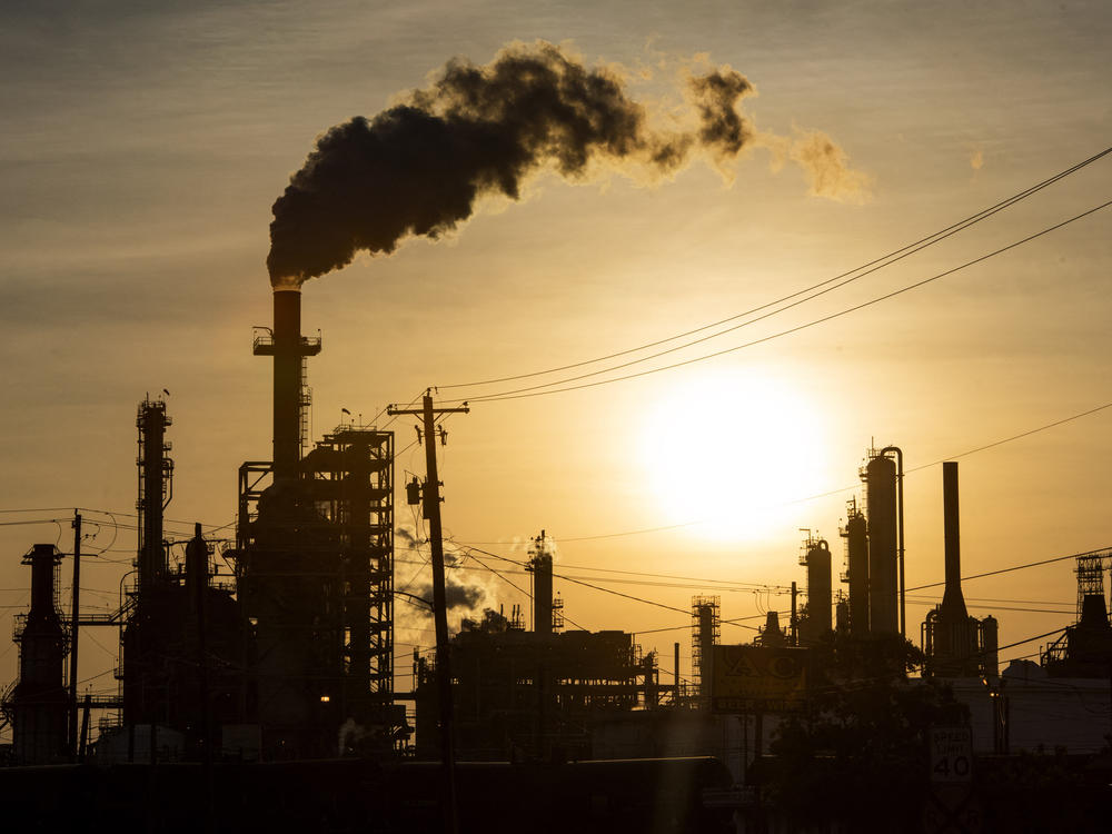 The sun sets behind an oil refinery in Texas. Almost every piece of plastic is made from fossil fuels.