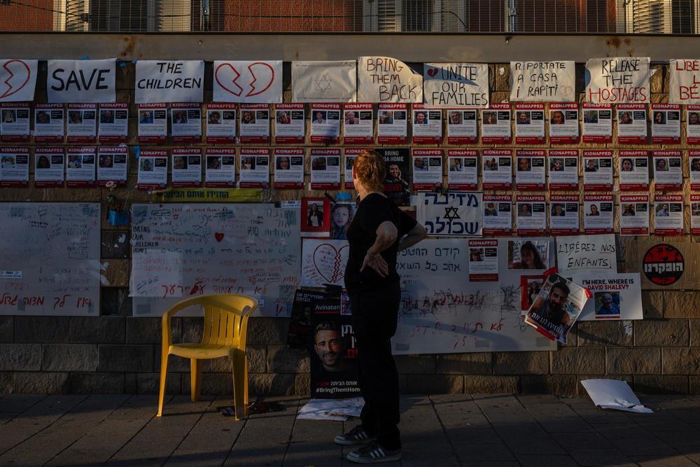 A woman looks at a wall in Tel Aviv with images of people held hostage in Gaza, on Oct. 20, 2023.