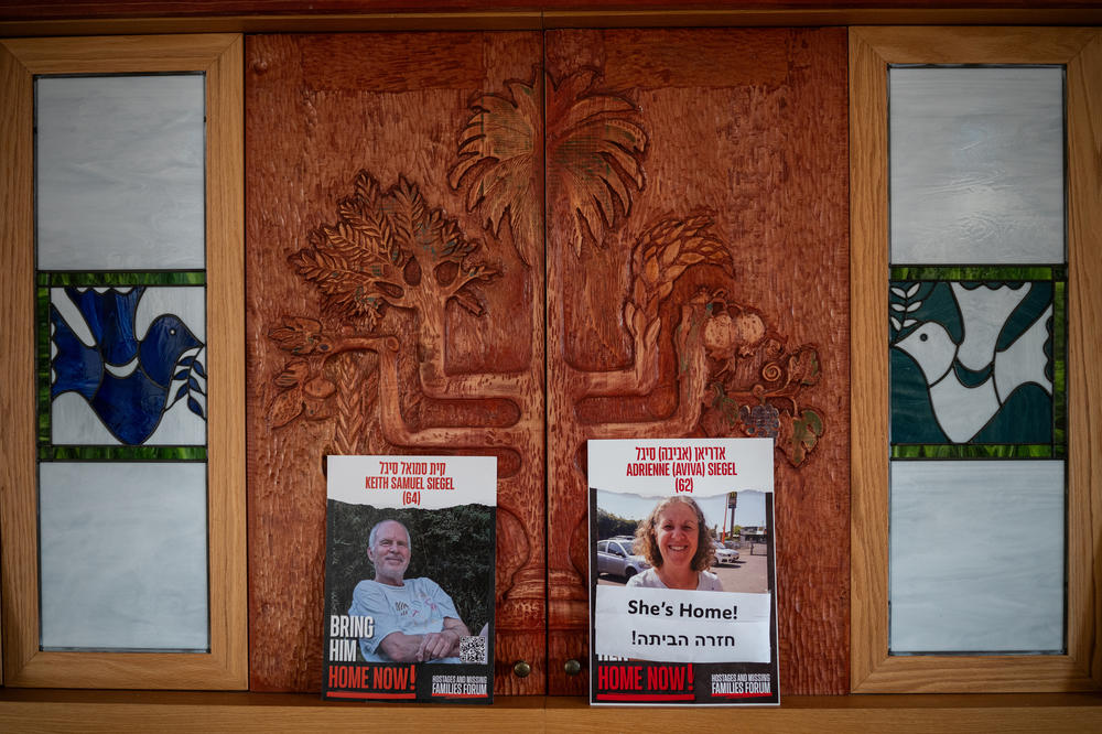 Posters showing Keith and Aviva Siegel are displayed on the Torah ark at Kibbutz Gezer's synagogue as Keith's brother, Lee Siegel, and Lee's wife Sheli speak to a group from the U.S. about their family, on March 25. The kibbutz is where Keith and Aviva Siegel met in 1980. Lee and Sheli Siegel have lived on the kibbutz since the 1970s.