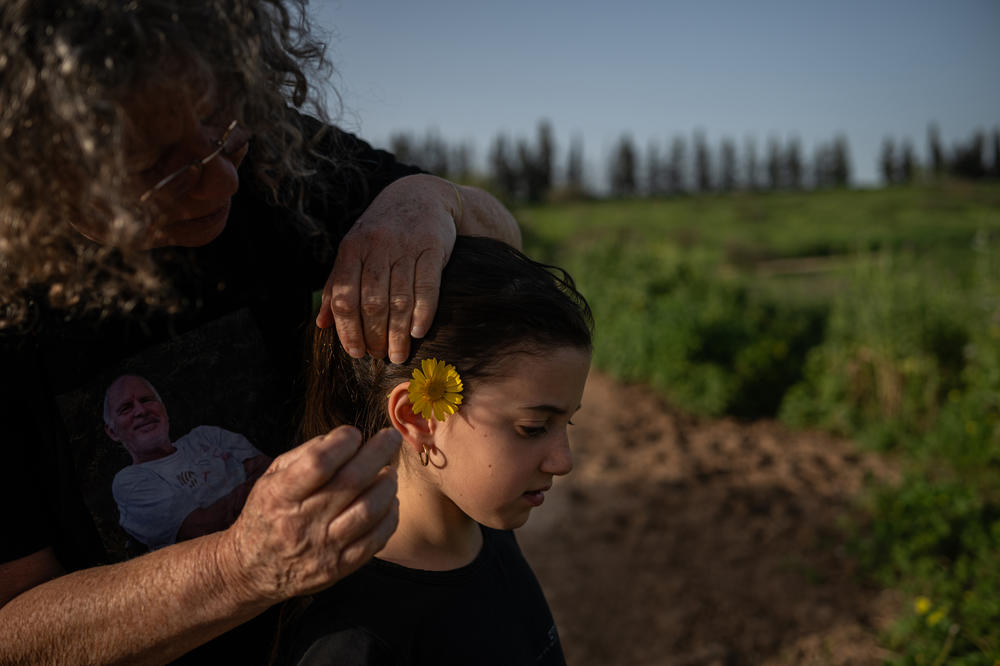 Aviva Siegel places a flower behind her eight-year-old granddaughter Yali Tiv's ear as they go for a walk near Kibbutz Gazit on March 26. 