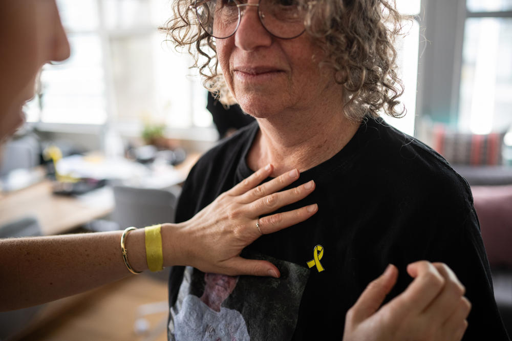 Shir Siegel, 28, places a yellow-ribbon pin symbolizing the campaign to free the hostages on her mother Aviva's shirt before an interview at the Hostage and Missing Families Forum headquarters in Tel Aviv, March 28. The organization was started in the wake of the Oct. 7 attacks to advocate for the release of the hostages and support their families.