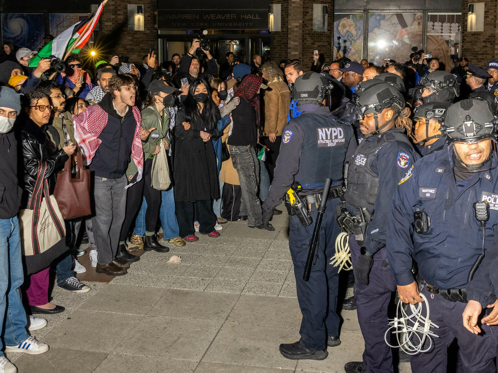 NYPD officers face pro-Palestinian protesters on Monday night after clearing an encampment on NYU's campus.