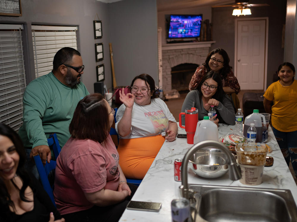 Caitlynn Almance (in the orange skirt) talks with family members at her parents' home in Odessa, Texas.